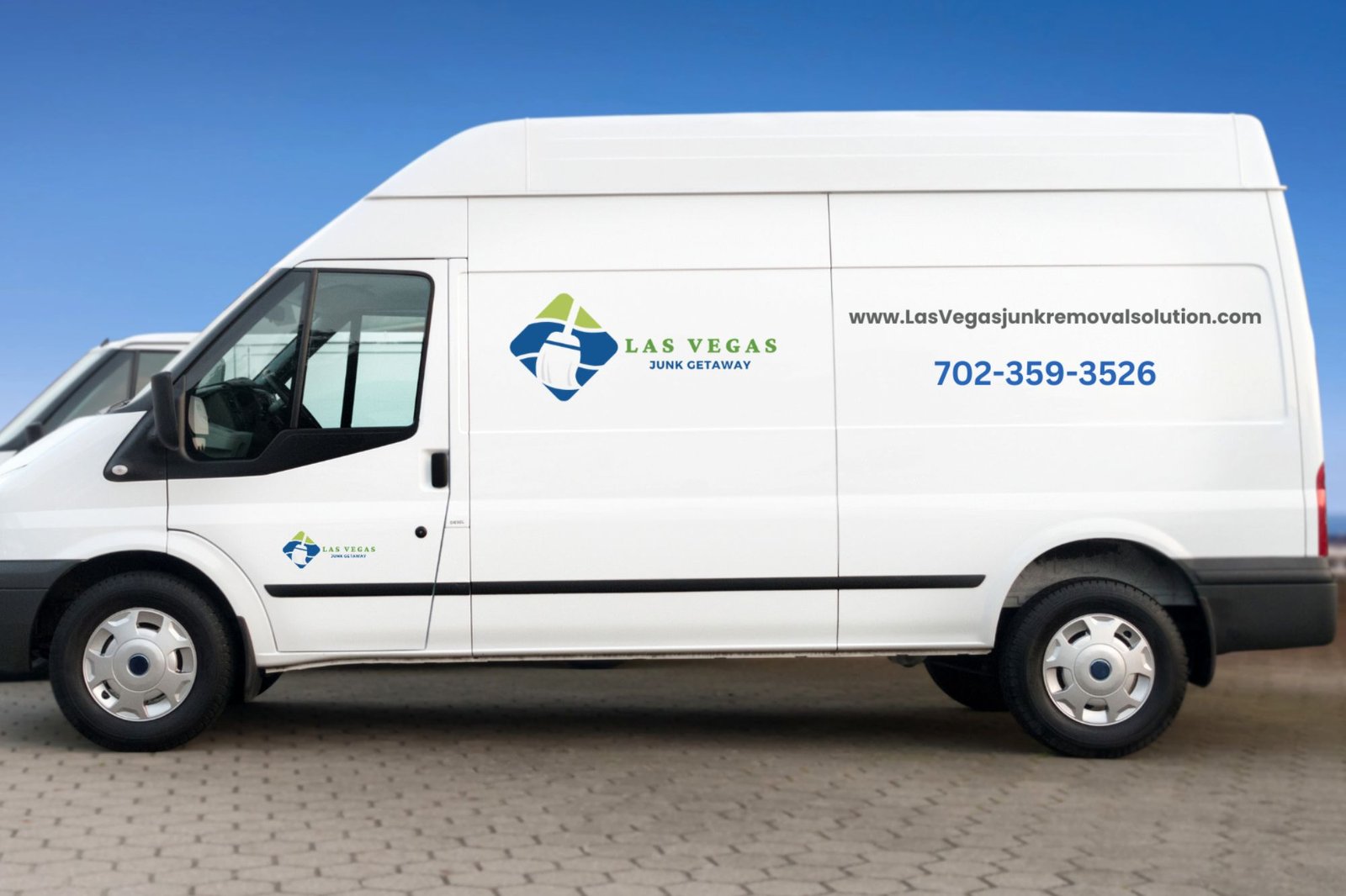 Two white vans are stationed outside a brick building, indicating a junk removal service based in Las Vegas, NV.